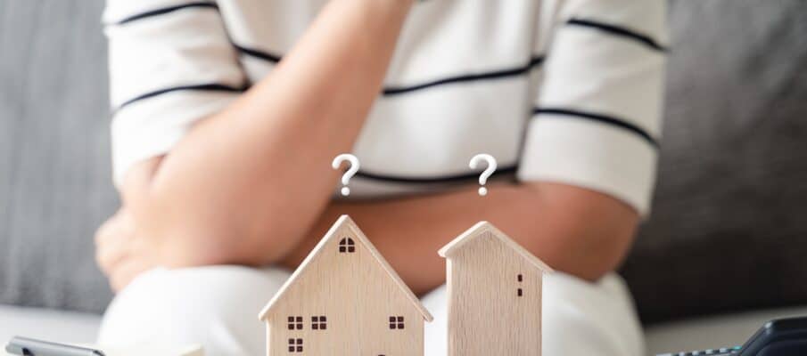 Woman,Is,Deciding,To,Choose,House,With,Small,Wooden,House